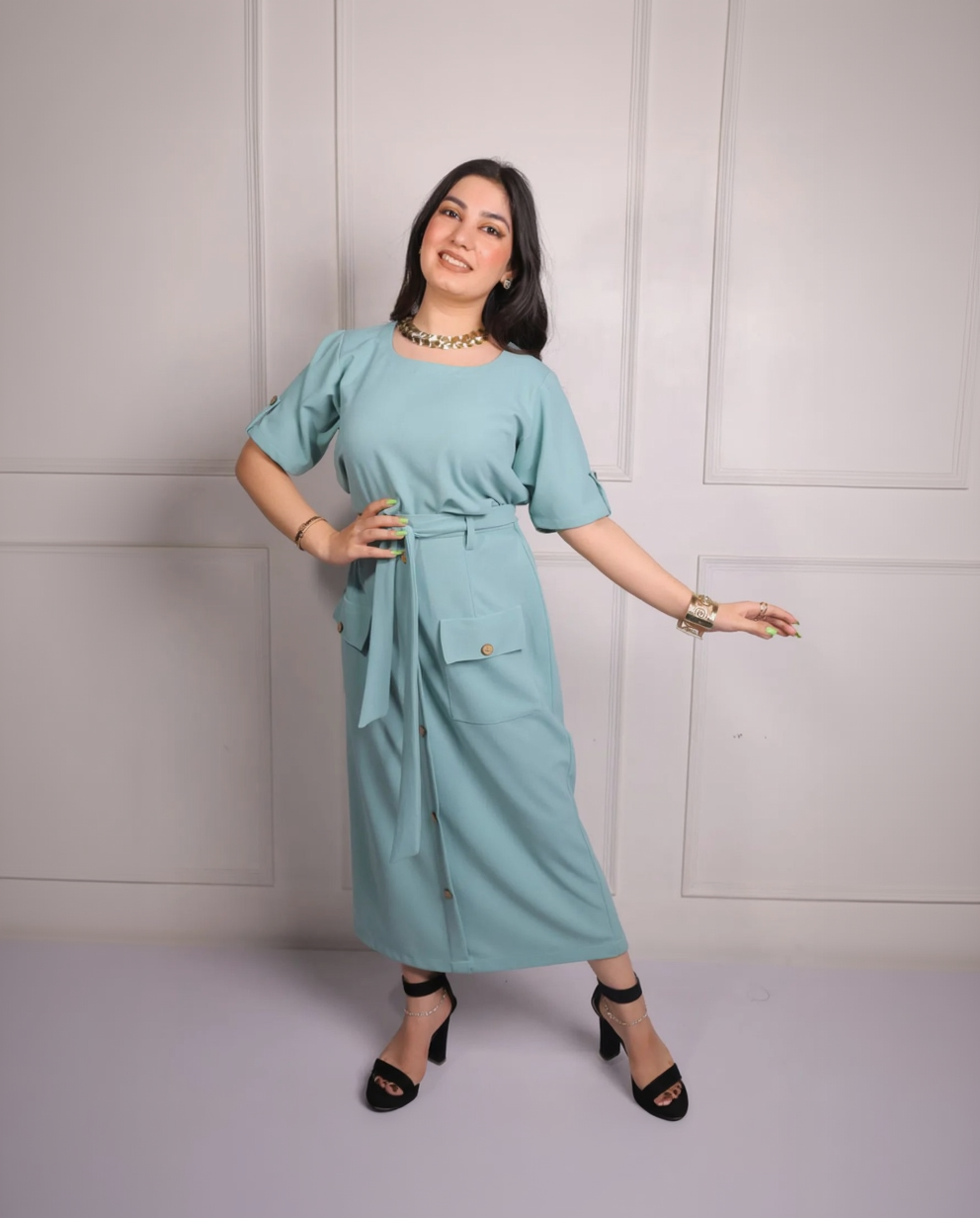 Woman wearing a light blue dress with a belt against a white background