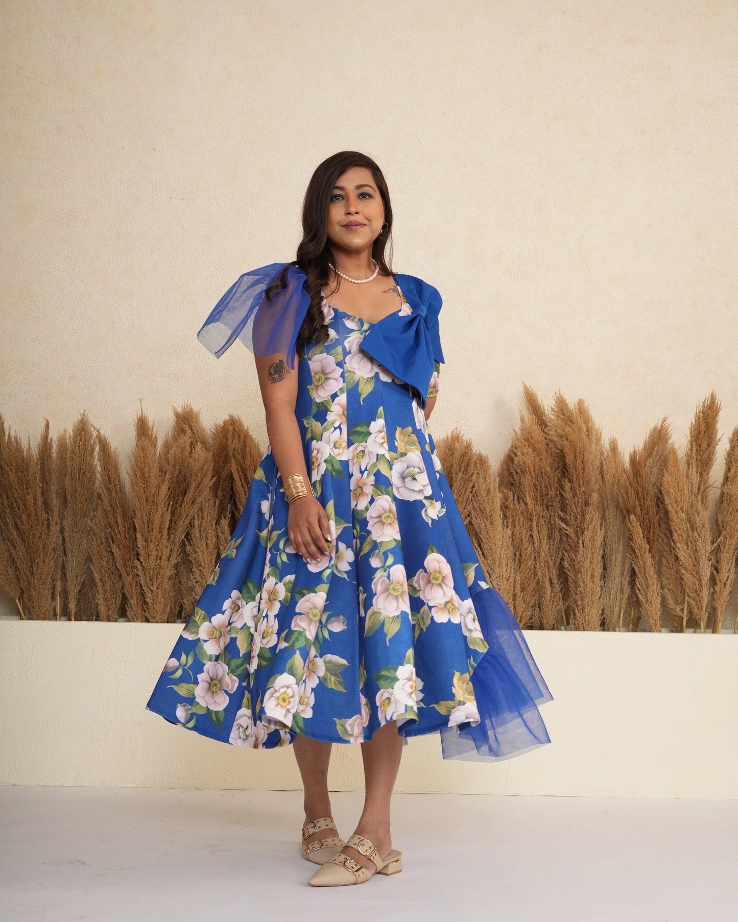 Woman wearing a blue floral dress with a plain background