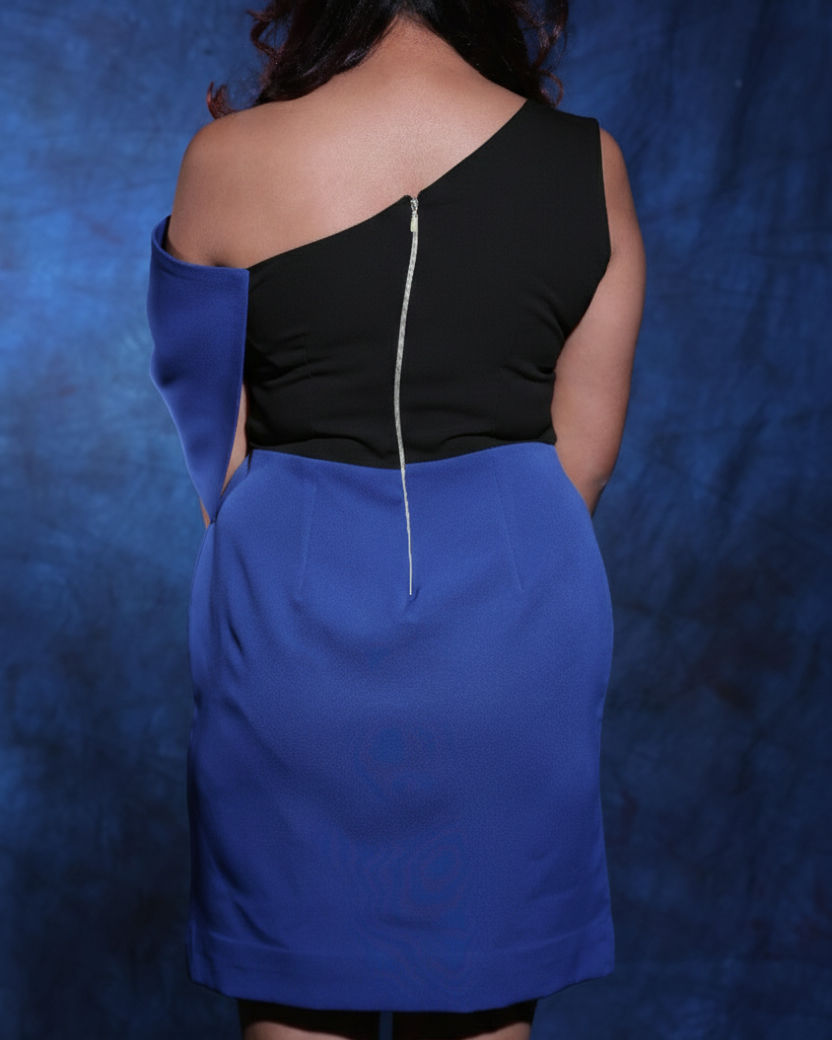 Person wearing a black top and blue skirt against a blue background
